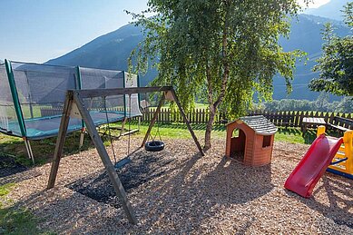 Junge spielt auf dem Outdoor Spielplatz des Kinderhotels Stefan im Pitztal.