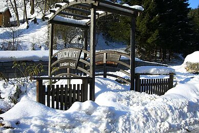 Eingangspforte in den Garten des Kinderhotels Bruckwirt im Winter.