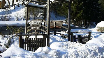 Eingangspforte in den Garten des Kinderhotels Bruckwirt im Winter.