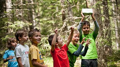 Kinder bei einer Schatzsuche im Wald im Hotel Engel Gourmet & Spa in Südtirol