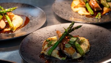 Drei Teller mit leckerem Essen aus der Sterneküche im Familienhotel Bella Vista in Südtirol.