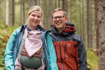 Eltern wandern mit ihrem Baby durch die Natur nahe des Familotels Kaiserhof 