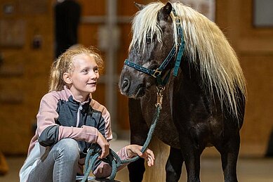 Das Mädchen freut sich das Pony im Elldus Resort Im Erzgebirge auszuführen.