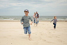 Eine Familie genießt die Zeit am Strand des Familien Wellness Hotel Seeklause an der Ostsee.