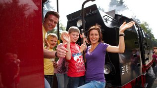 Familie fährt beim Familienurlaub im Harz mit der historischen Brockenbahn.