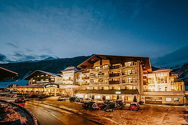 Außenansicht des Familienhotels Alpenhotel Kind in Tirol bei Nacht. Das Hotel ist schön beleuchtet und liegt direkt am familienfreundlichen Skigebiet. 