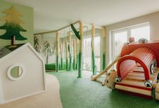 Ein fantasievoll gestalteter Indoor-Spielbereich mit Kletterelementen begeistert Kinder im Familienhotel Friedrichshof.