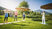 Frauen bei einer Yoga Stunde in der Natur im Familienurlaub im Familienhotel Landgut Furtherwirt.