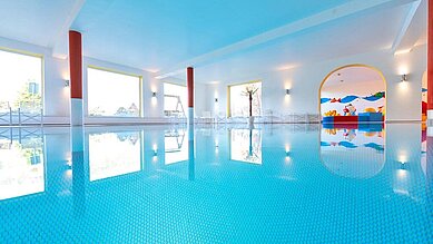 Schwimmbad mit Blick zum Babybecken und Panoramafenstern im Familienhotel Mein Krug im Fichtelgebirge.