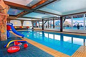 Das große Hallenbad mit Panoramafenster im Familienhotel Bavaria im Allgäu 