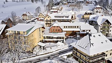 Das Familienhotel Engel im Schwarzwald umgeben von verschneiter Landschaft.