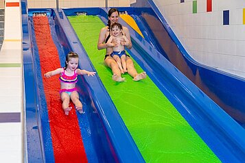 Kinder rutschen die Wasserrutsche im Familienhotel Familien Resort Petschnighof in Kärnten.