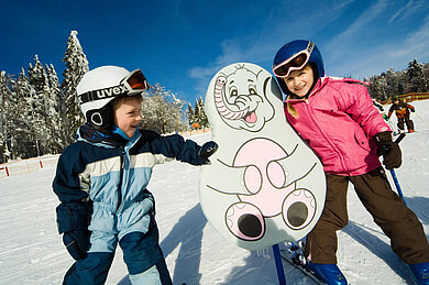 Zwei Kinder auf Skiern im Kinder Ski-Zirkus im Bayerischen Wald. 