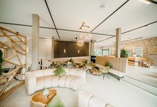 Die stilvolle Lounge mit Naturmaterialien macht den Aufenthalt im Familienhotel Friedrichshof besonders gemütlich.