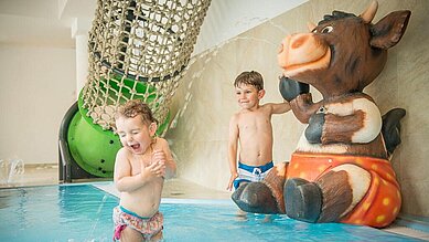 Zwei Kleinkinder planschen im Kleinkinderbecken des Hallenbads im Landgut Furtherwirt in Tirol.