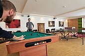 Gemeinsames Billard spielen im Teensraum im Familienhotel Amiamo im Salzburger Land.