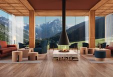 Gemütlicher Loungebereich mit Kamin und Panoramablick auf die Berge im Familienhotel Bella Vista in Südtirol.