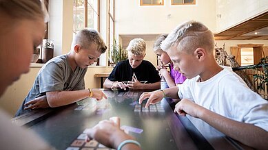 Teens spielen im Happy-Club ein Gemeinschaftsspiel im Familienhotel Alphotel Tyrol Wellness & Family Resort in Südtirol.