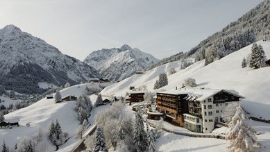 Das Familienhotel Alphotel im Allgäu umgeben von einer winterlichen Berglandschaft