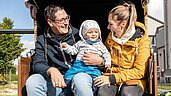 Familie mit Kleinkind genießt die herbstliche Sonne in einem Strandkorb im Familienurlaub an der Nordsee