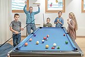 Eine Familie spielt zusammen Billard im Familienhotel Gorfion in Liechtenstein