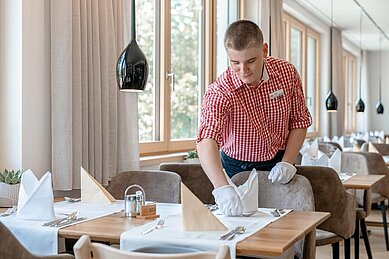 Kellner deckt die Tische im Restaurant des Familienhotels Amiamo ein