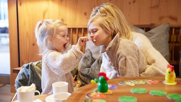 Mutter mit ihren beiden Kindern beim Kuchenessen im Familienhotel Das Bayrischzell