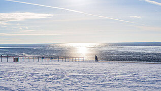 Bei einem Spaziergang über den Deich im Winter kann man den Schneebedeckten Strand bestaunen.