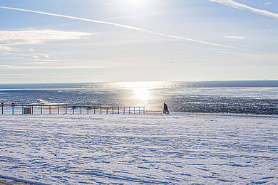 Bei einem Spaziergang über den Deich im Winter kann man den Schneebedeckten Strand bestaunen.