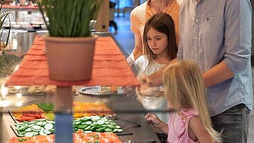 Kinder ab ausgiebigen Kuchenbuffet im Restaurant des Familienhotels Schreinerhof im Bayerischen Wald.