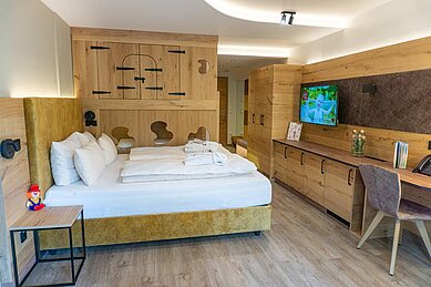 Gemütliches Familienzimmer mit einem Doppelbett und zwei Kinderbetten im Familienhotel Landhaus zur Ohe im Bayerischen Wald.